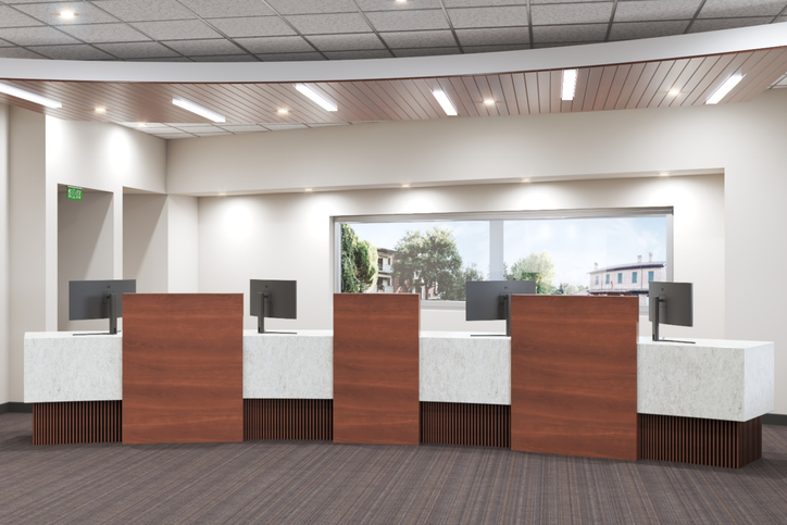 Modern bank branch teller line with recessed lighting and wood ceiling detail, maintained through facilities management services for banks